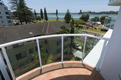 a balcony with a view of a building and the water at Mirage 502 - linen not included in Tuncurry