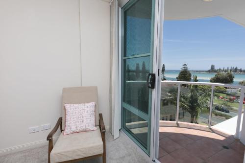 a balcony with a chair and a view of the ocean at Mirage 502 - linen not included in Tuncurry