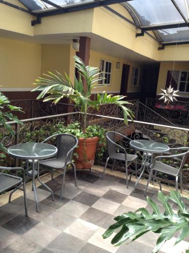 a patio with two tables and chairs and plants at Hotel Palacio in Uruapan del Progreso