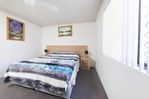 a white bedroom with a bed and a window at Breakers 3 - linen not included in Forster