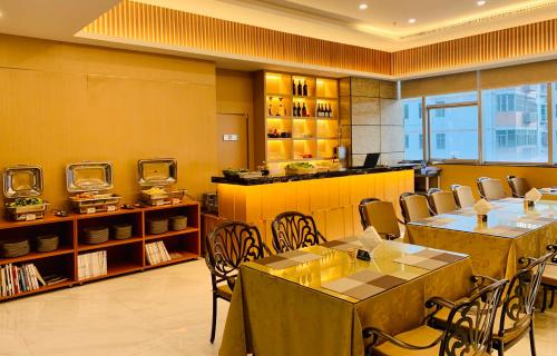 Un restaurante con mesas y sillas en una sala. en Golden Central Hotel Serviced Residence-Xin Hao E Du金中环服务公寓新浩e都店, en Shenzhen