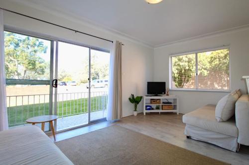 ein Schlafzimmer mit einem Bett und einer Glasschiebetür in der Unterkunft Ocean Views in Huskisson