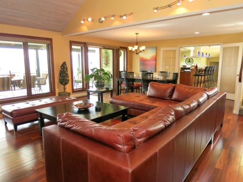 a living room with a leather couch and a table at A View of the Lake B & B in West Kelowna