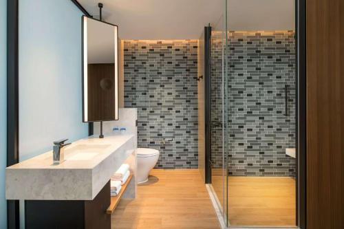 a bathroom with a sink and a glass shower at Fairfield by Marriott Guangzhou Tianhe Park in Guangzhou