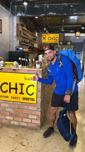 a man with a backpack standing in front of a store at OK CHIC PHUKET HOSTEL in Phuket Town