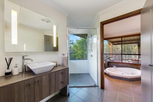 a bathroom with a tub and a sink and a bath tub at Cedars Mount View (Adults Only) in Mount View