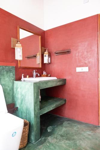 a bathroom with a sink and a mirror at Cranganor History Café & Riverside Château in Parūr
