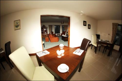 a dining table and chairs in a living room at All the Twos Lodge in Clifden