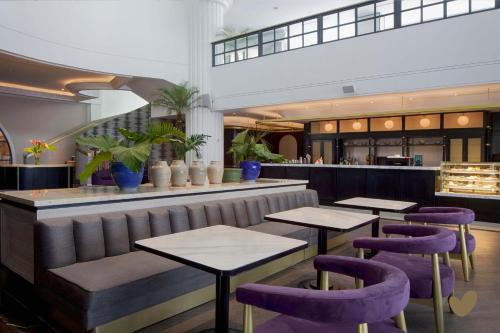 a restaurant with purple stools and tables at Goodrich Suites, Jakarta in Jakarta