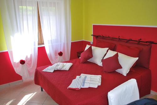 Una cama roja con dos toallas encima. en B&B L'Ancora, en Agropoli