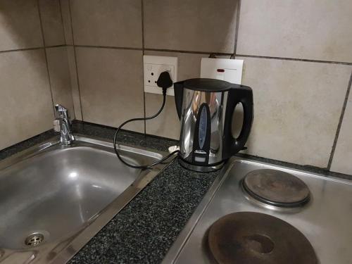 a coffee pot sitting on a counter next to a sink at The Bridgeview in Johannesburg
