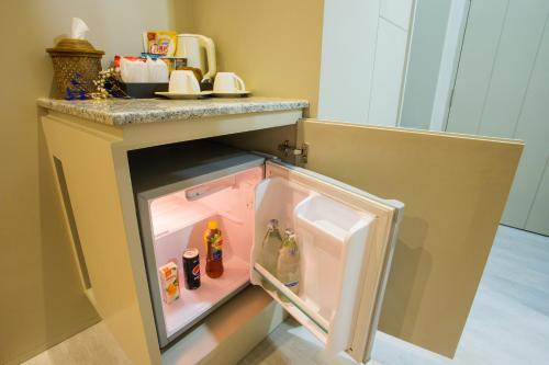 a small refrigerator with its door open in a kitchen at Lanna Thaphae Hotel in Chiang Mai
