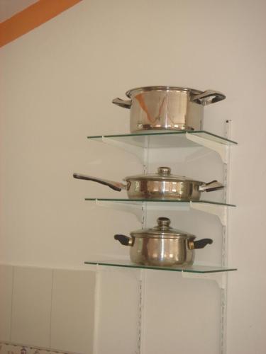 three pots and pans on shelves in a kitchen at Dre Broeders Apartments Juan Dolio in Juan Dolio