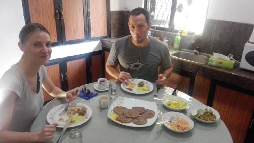 a man and a woman sitting at a table eating food at Mango Roots in Gampaha