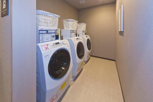 a row of washers and dryers in a laundry room at Hotel Route-inn Yamaguchi Yuda Onsen in Yamaguchi