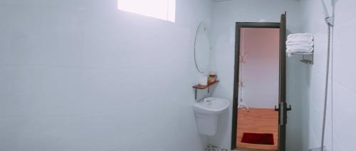 a white bathroom with a toilet and a sink at Sunshine Homestay in Phong Nha
