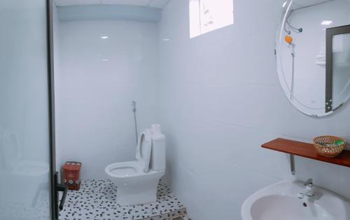 y baño con aseo, lavabo y espejo. en Sunshine Homestay, en Phong Nha