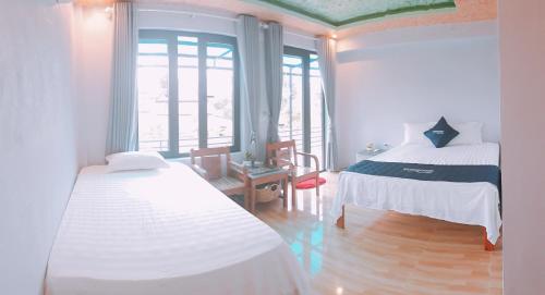 1 Schlafzimmer mit 2 Betten in einem Zimmer mit Fenstern in der Unterkunft Sunshine Homestay in Phong Nha
