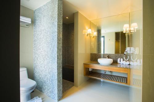 a bathroom with a sink and a toilet and a mirror at Lanna Thaphae Hotel in Chiang Mai