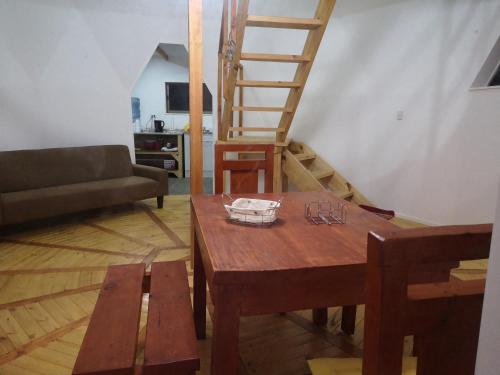 a living room with a wooden table and a ladder at Domos y Cabañas Algarrobo in Algarrobo