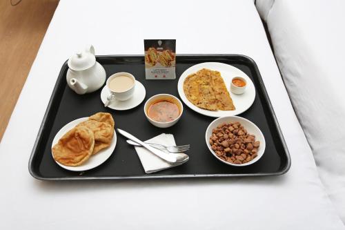 a tray of food with breakfast foods on a bed at Pemaling Lords Inn Dirang in Dirang Dzong