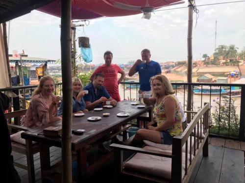 a group of people sitting around a wooden table at ST 63 Home Stay & Tour Kampong Khleang in Kâmpóng Khleăng