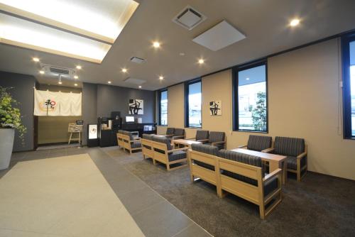 a waiting room with chairs and tables and windows at Hotel Route Inn Kasai Hojonoshuku in Kasai