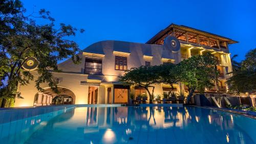 a villa with a swimming pool at night at The Lady Hill Hotel in Galle