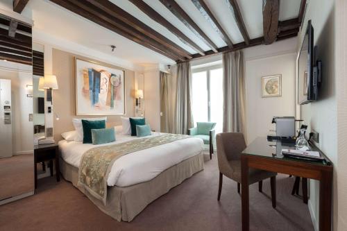 a hotel room with a large bed and a desk at Best Western Plus Hotel Sydney Opera in Paris