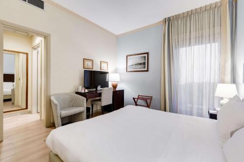a hotel room with a bed and a desk and a television at Villa Maria Hotel & SPA in Francavilla al Mare