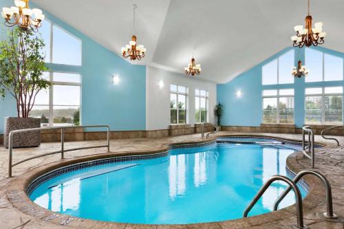a pool in a hotel with blue walls and windows at Days Inn by Wyndham Kingston in Kingston