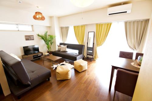 a living room with a couch and a tv at Reve K 302 in Naha