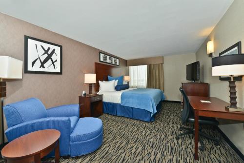 a hotel room with a bed and a desk at Wyndham Garden Elk Grove Village - O'Hare in Elk Grove Village