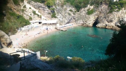 a beach with people swimming in the water at Apartments Topolo Dubrovnik in Dubrovnik