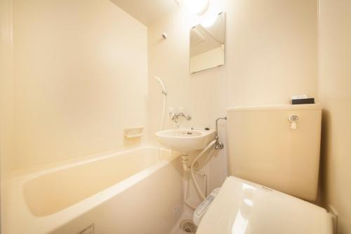 een witte badkamer met een toilet en een wastafel bij Posada Suimei in Hakone