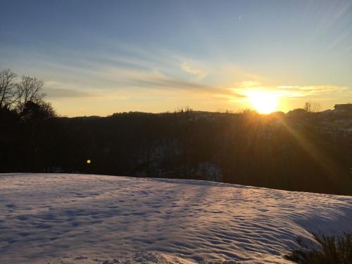 a snowy field with the sun setting in the background at Bauernhaus Pledlberg in Winzer