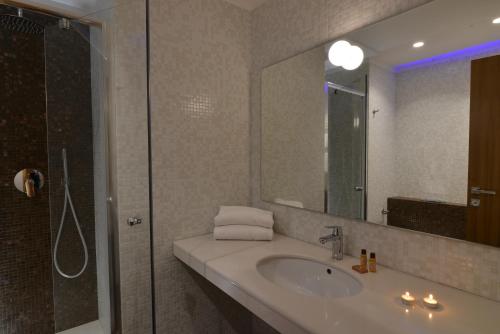 
a bathroom with a sink, mirror and bath tub at Hotel San Domenico Al Piano in Matera
