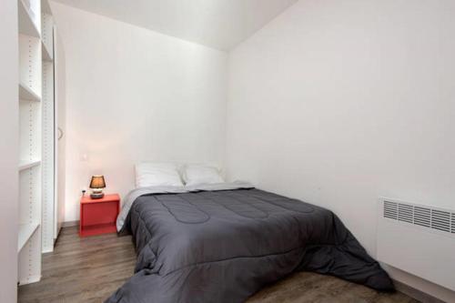 een slaapkamer met een bed en een rode tafel bij VILLA DEL Ré 10 in La Flotte