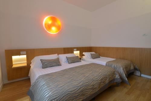 a room with two beds and a clock on the wall at Hotel San Domenico Al Piano in Matera