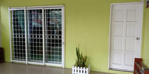 a room with a gate and a white door at Sepanggar Kingfisher Homestay in Kota Kinabalu
