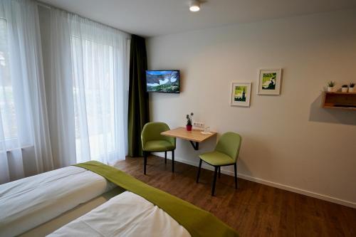 a bedroom with a bed and a table and chairs at Busses Guesthouse in Freiburg im Breisgau