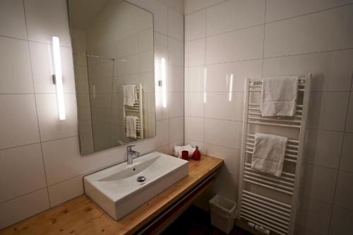 a white bathroom with a sink and a mirror at Busses Guesthouse in Freiburg im Breisgau