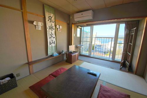 白濱的住宿－Shirahama White Beach House - Self Check-In Only，客厅设有桌子和大窗户