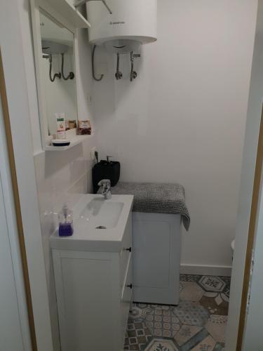 een witte badkamer met een wastafel en een spiegel bij Stone Wall Apartment Izola in Izola
