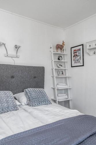 a bedroom with a bed and a white wall at Opsahl Gjestegaard in Bodø