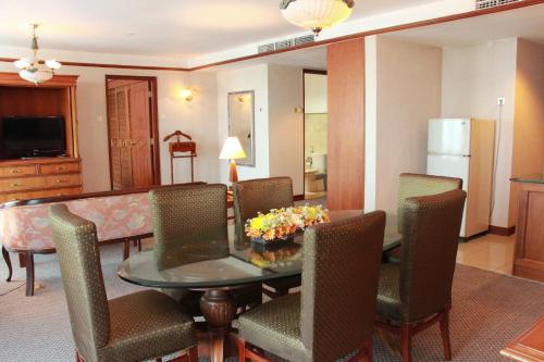 a living room with a dining room table and chairs at Millennium Hotel Sirih Jakarta in Jakarta