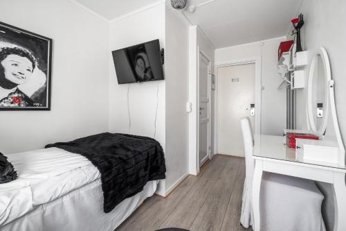 a white bedroom with a bed and a desk at Opsahl Gjestegaard in Bodø
