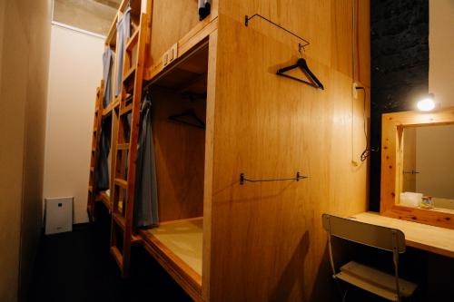 北谷町にあるAIEN（アイエン）Coffee & Hostelのデスク、鏡、キャビネットが備わる客室です。