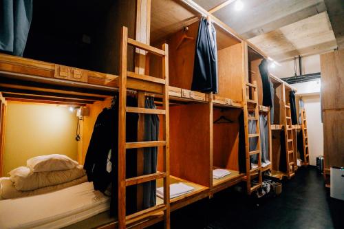 a group of bunk beds in a room at AIEN Coffee & Hostel in Chatan