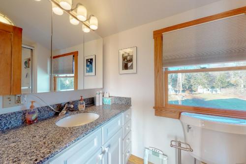 a bathroom with a sink and a mirror and a toilet at Serene Newagen House in Southport